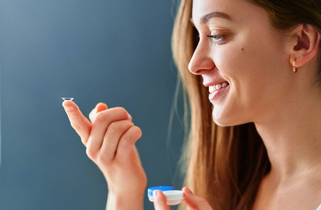 A person looks at the contact lens they have resting on their index finger.