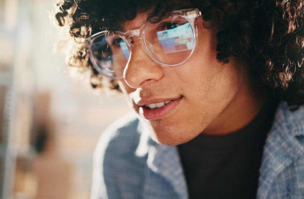 Person wearing clear eyeglasses in a modern workspace.